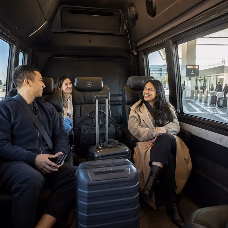 Passengers loading luggage while boarding an Morristown group shuttle