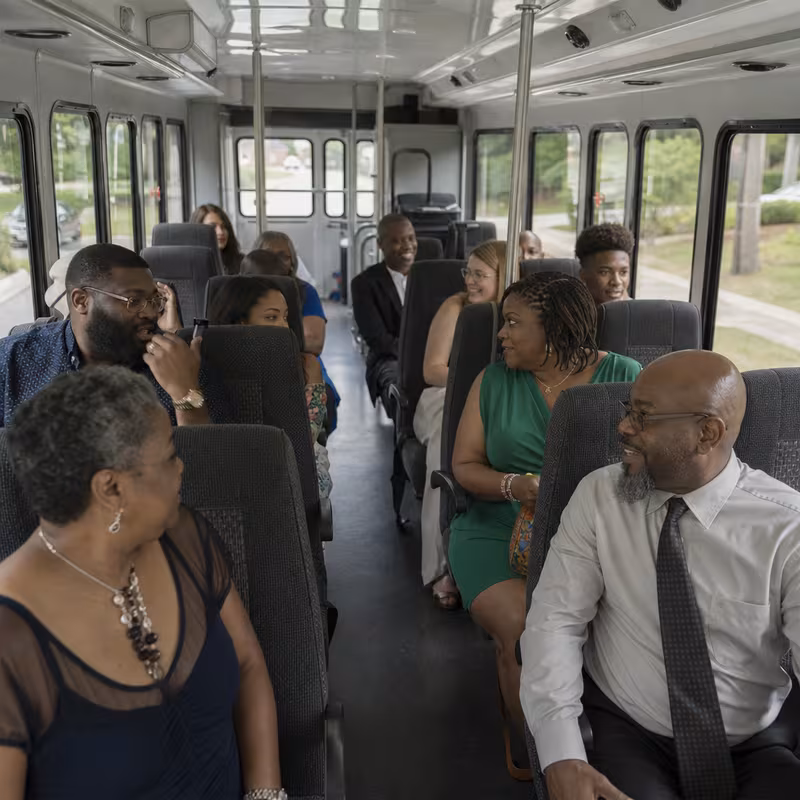 Group boarding a white charter bus for Private Event Transportation transportation in Morristown