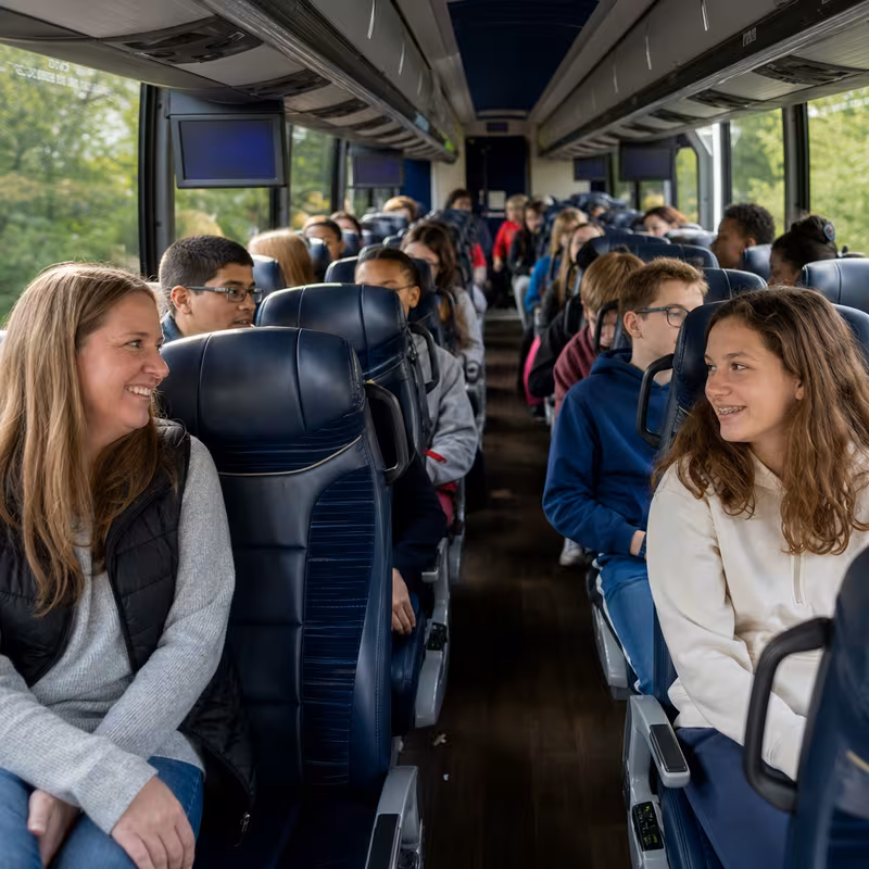 Group boarding a white charter bus for School Transportation transportation in Morristown