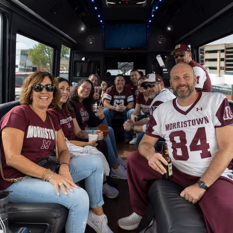 Group boarding a white charter bus for Sporting Event Transportation transportation in Morristown